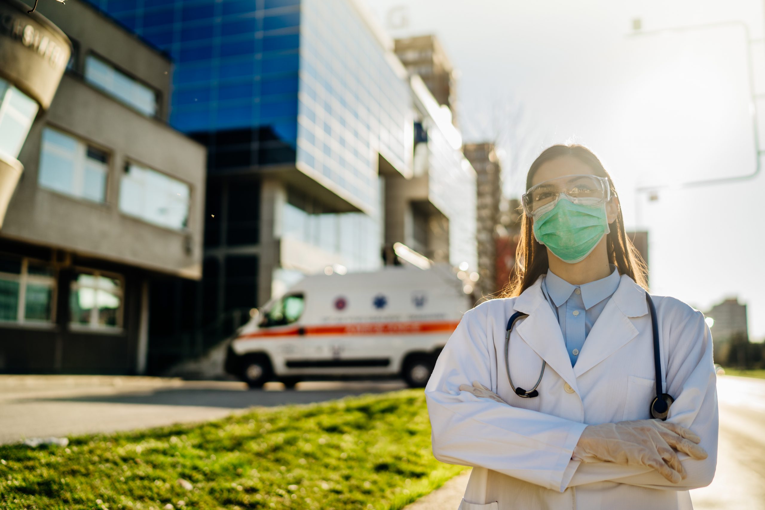 Doctor wearing a mask in front of a hospital