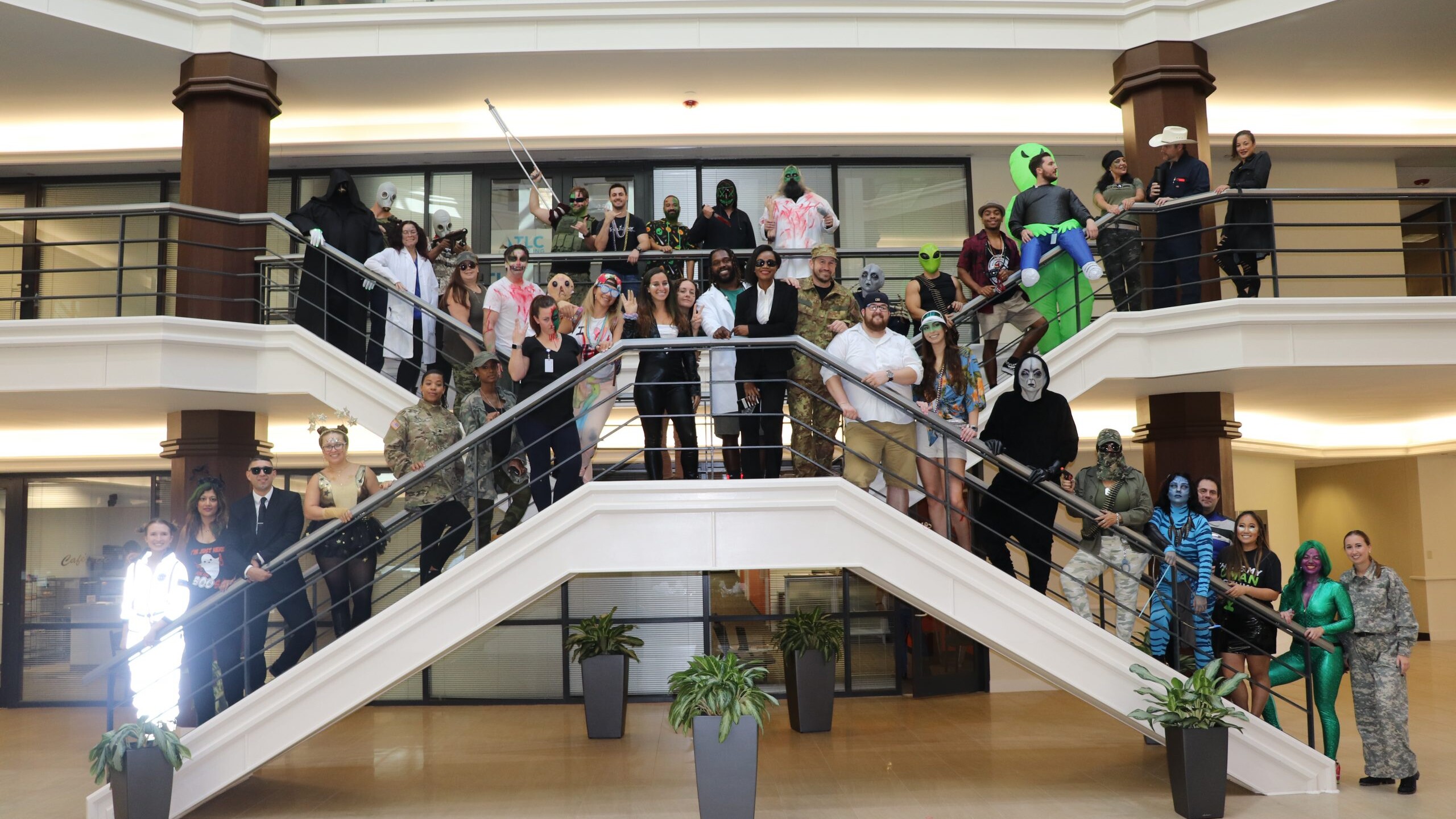 Employees standing on stairwell in Holloween costumes
