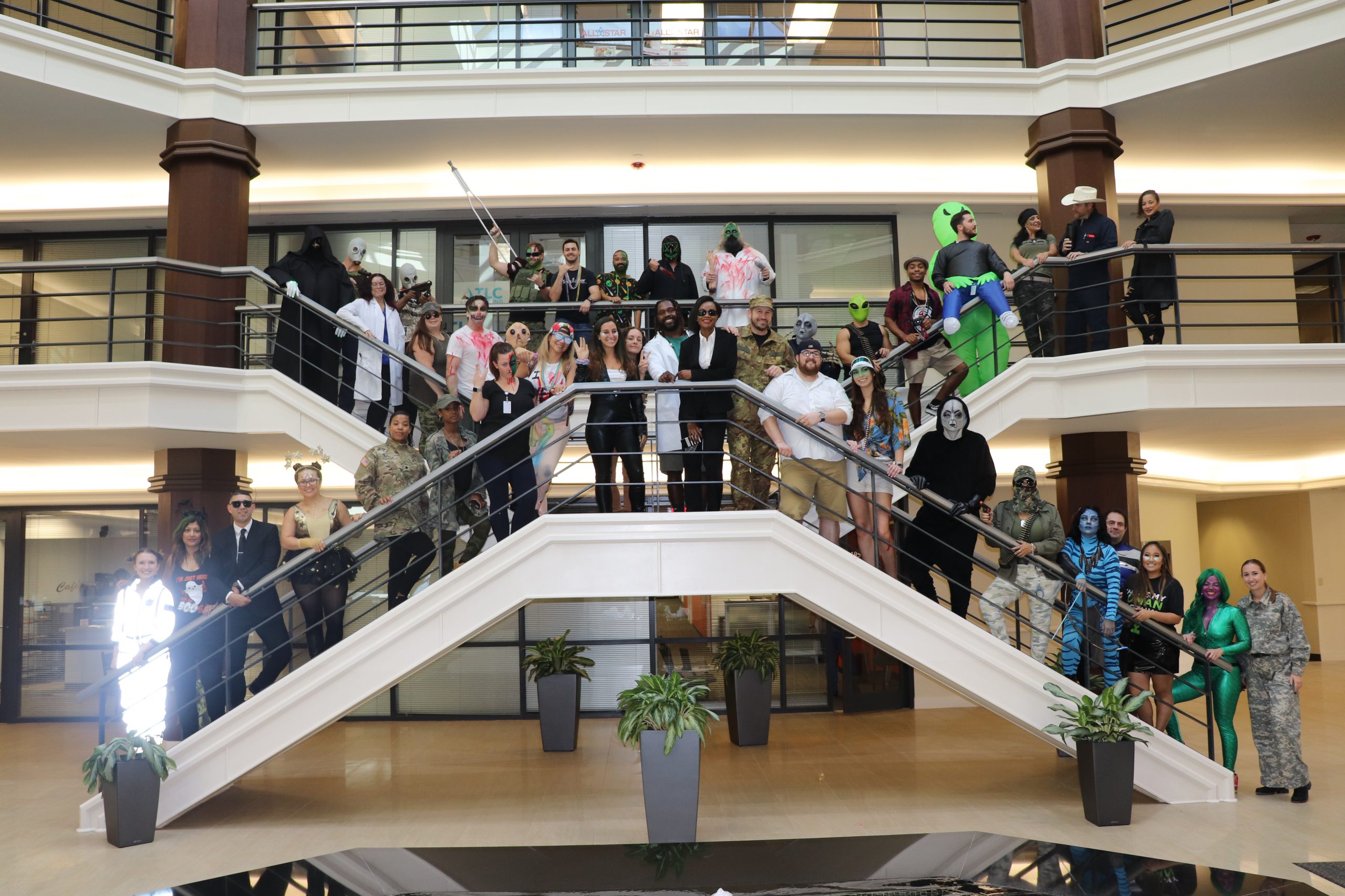 Employees standing on stairwell in Holloween costumes
