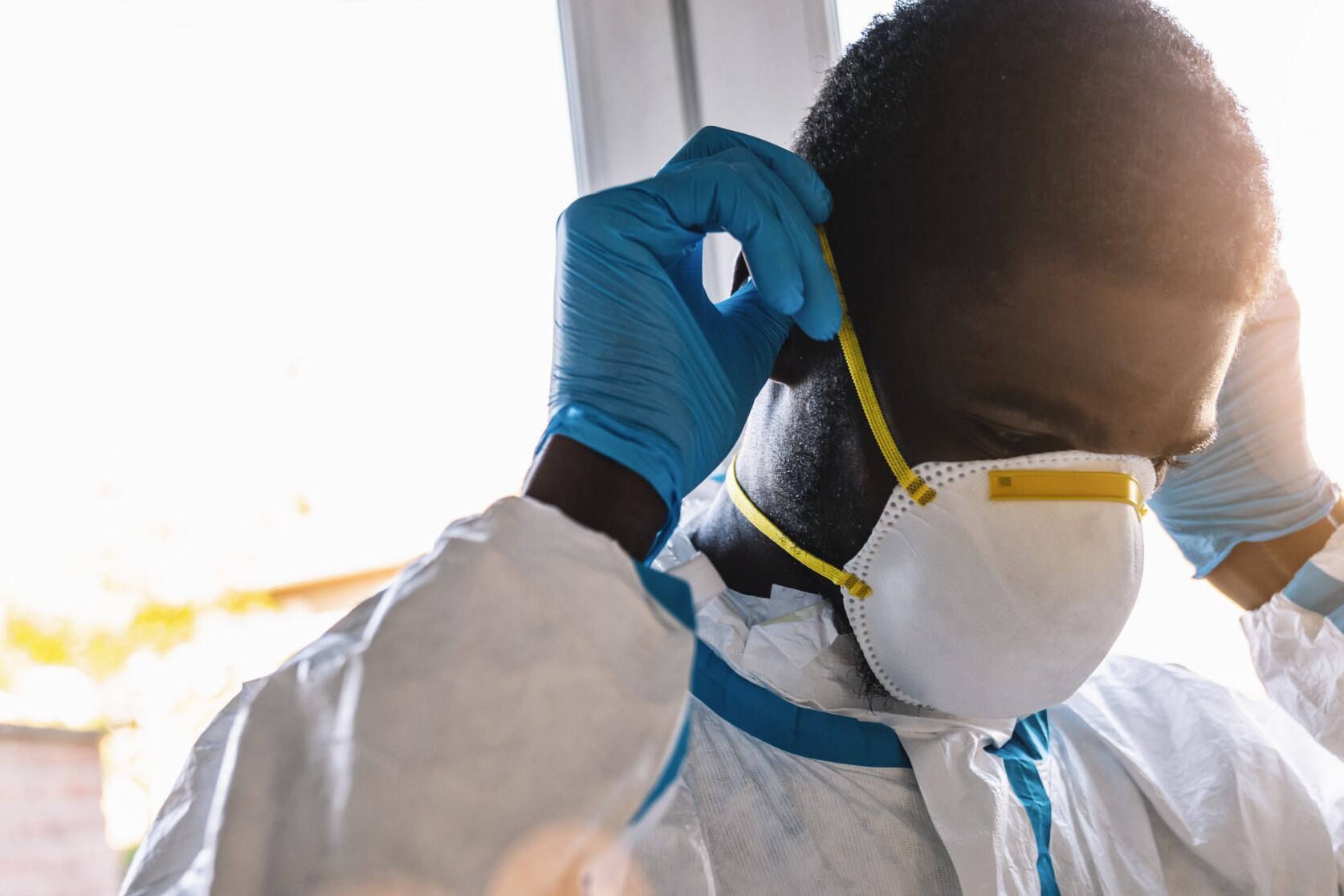 caregiver in protective clothing puton mouth protection mask N95, ff2, ffp3 in the intensive care unit of a clinic