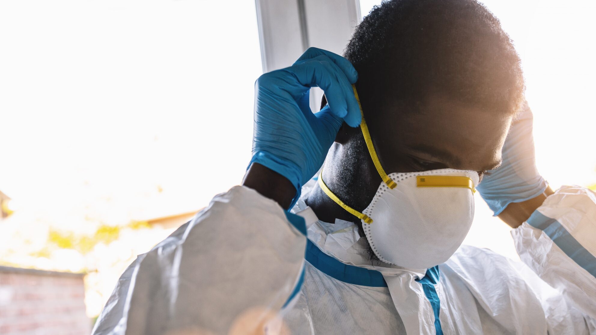 caregiver in protective clothing puton mouth protection mask N95, ff2, ffp3 in the intensive care unit of a clinic