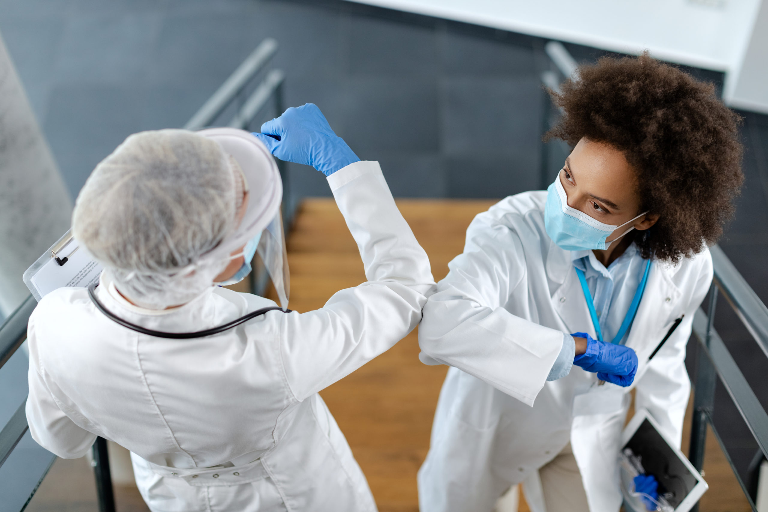 Two healthcare workers greeting with elbows due to coronavirus pandemic.
